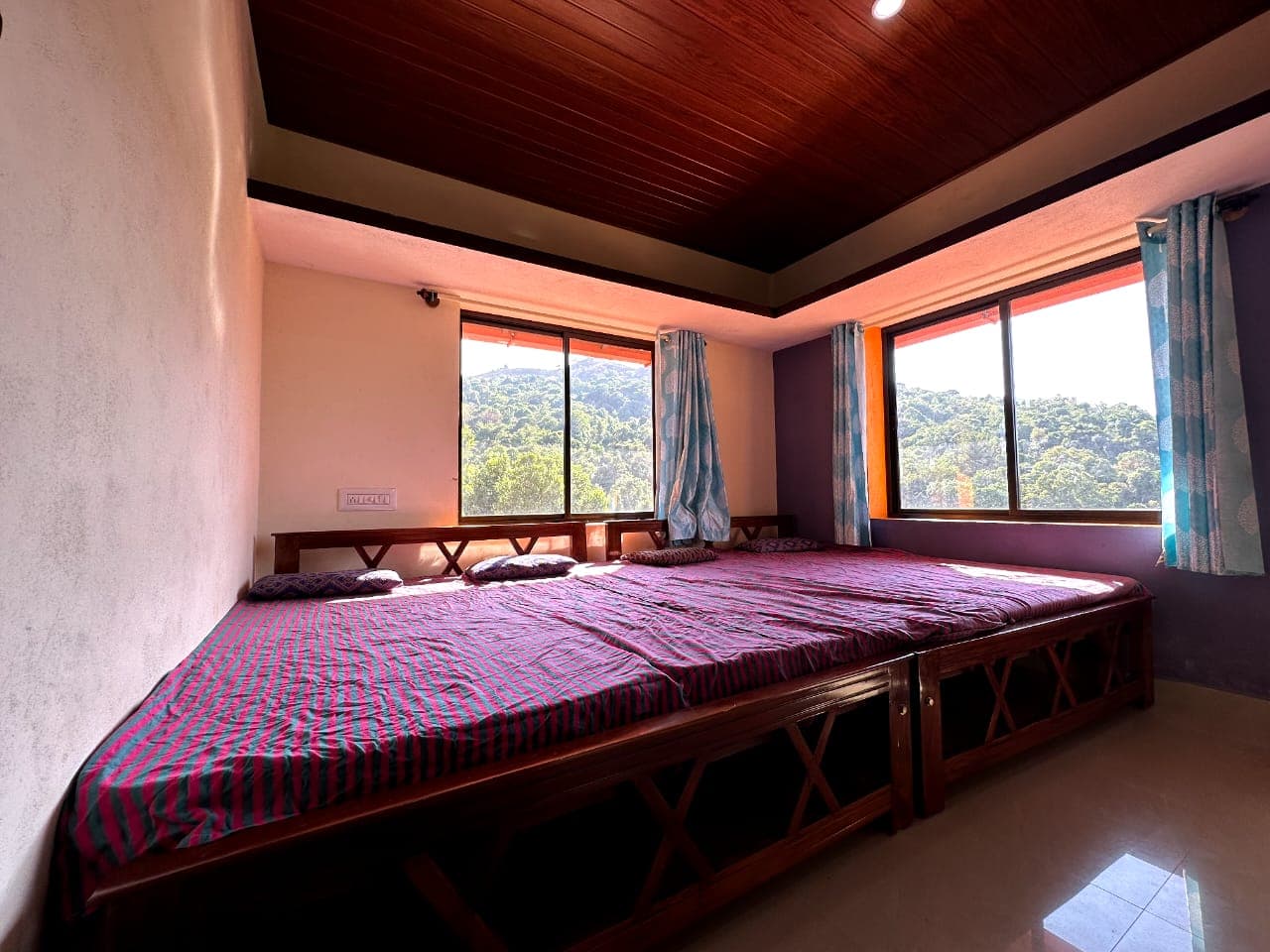 Large room with wooden ceiling and mountain view windows at Satish Mullodi Home Stay, Kudremukh