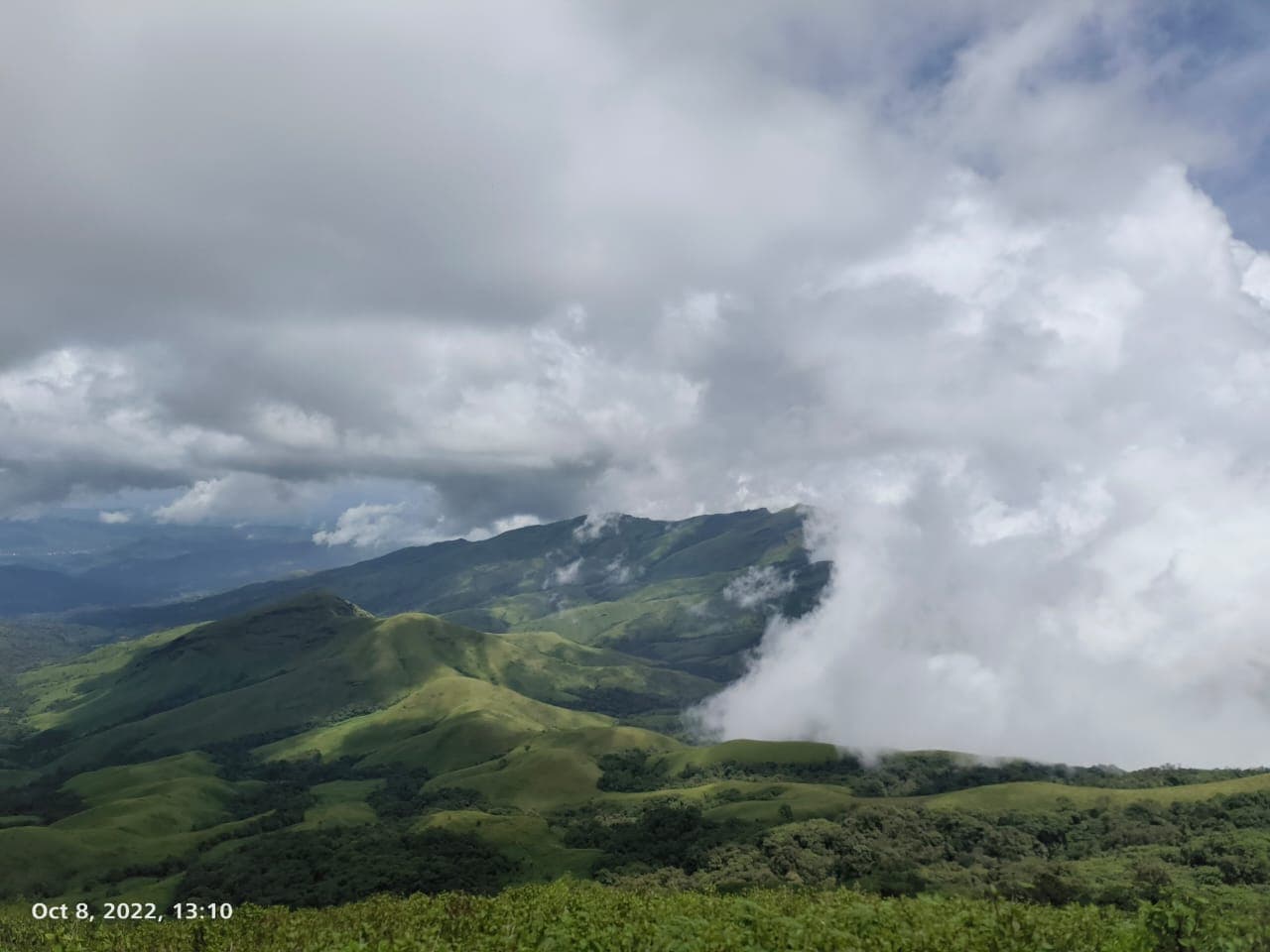 Rolling green grassland ridges and clouds on the Kudremukh peak trek
