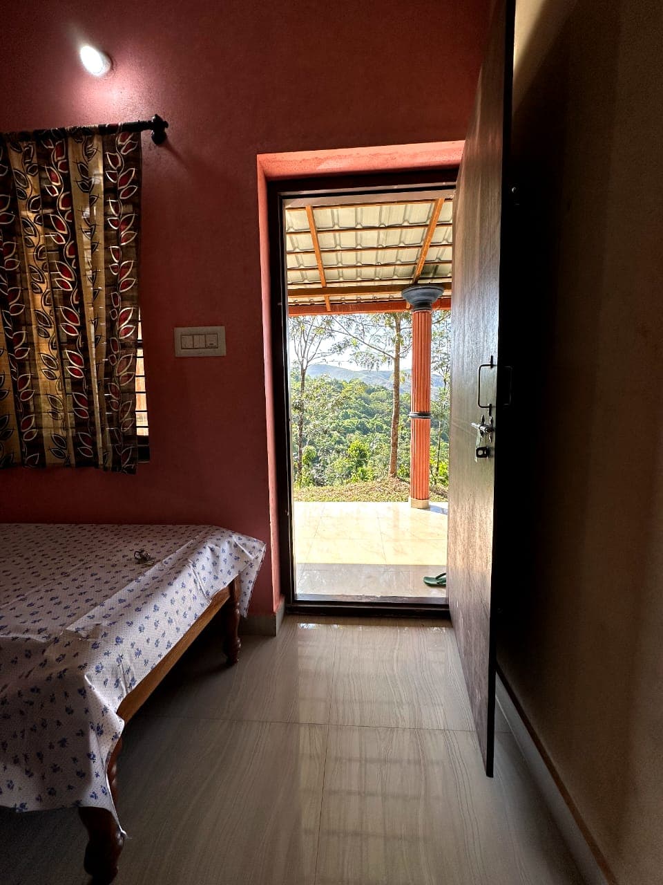 Room doorway opening onto a veranda with forest and hill view at Mullodi, Kudremukh